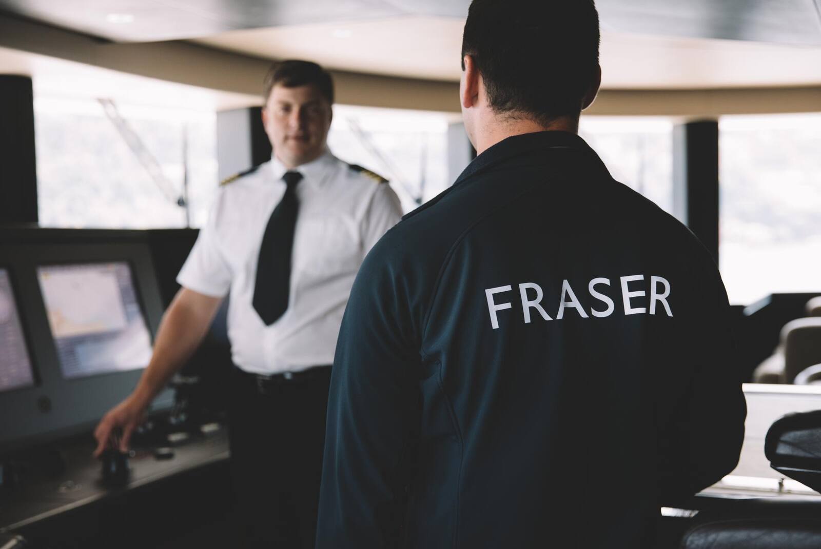 A captain at the helm on the bridge of a yacht