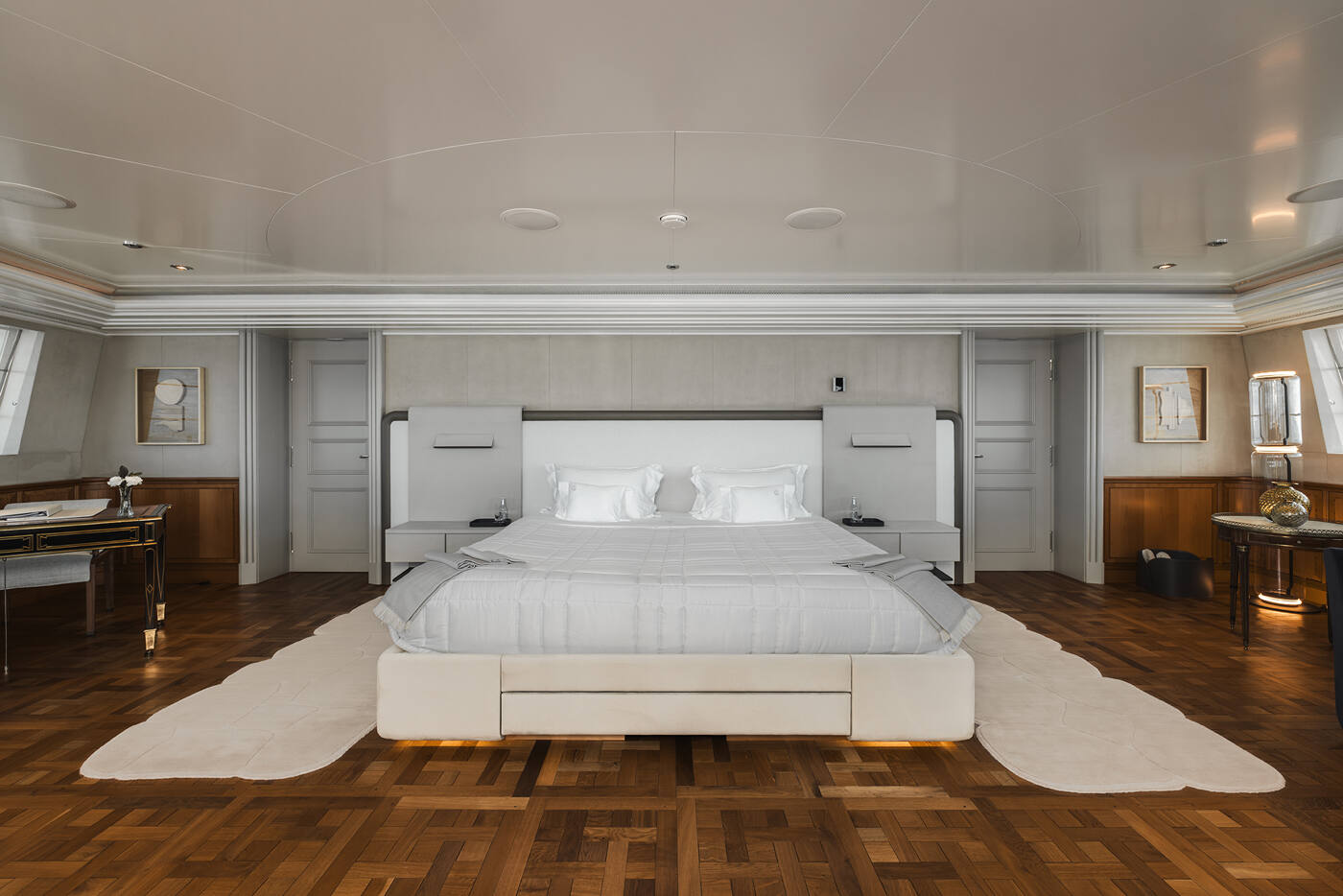 The owner's stateroom aboard CARINTHIA VII, with parquet flooring, an upholstered headboard and a writing desk