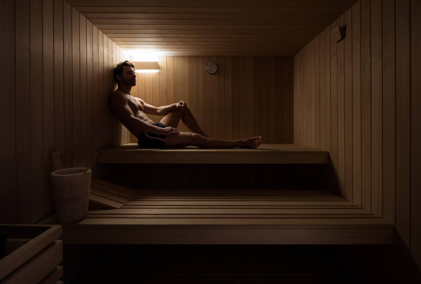 A guest resting alone on the timber benches of the onboard sauna